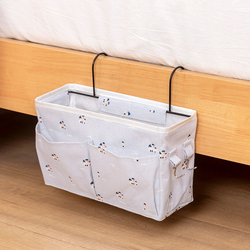 Bedside storage bag with metal hooks, featuring multiple pockets for holding items like books and snacks. Available at Shopway.