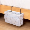 Bedside storage bag with metal hooks, featuring multiple pockets for holding items like books and snacks. Available at Shopway.