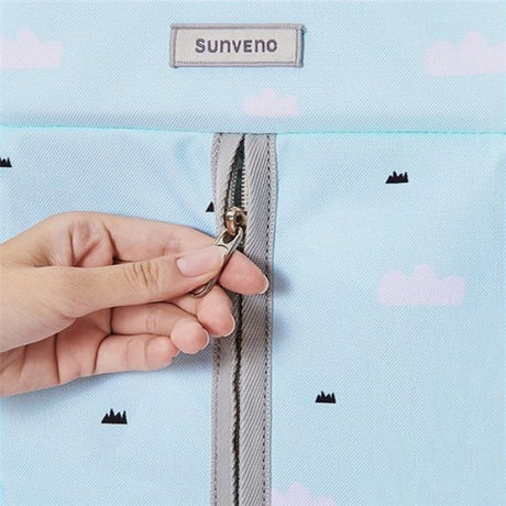 Close-up of a hand zipping a blue multifunctional Shelf Bag for organizing diapers, by Shopway.