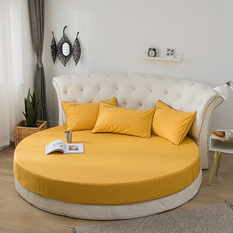 Yellow round bedspread with matching pillows on a circular bed, featuring a plain design and simple style, available at Shopway.