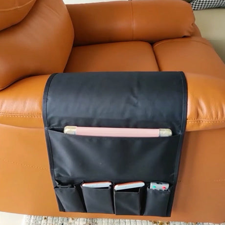 Black bedside storage hanging bag attached to a sofa, ideal for holding remote controls, iPads, and magazines. Available at Shopway.