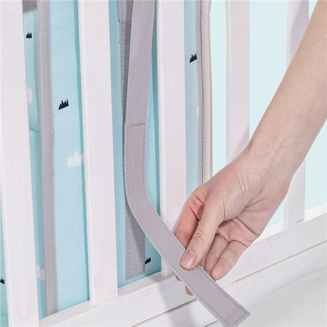 Hand adjusting blue multifunctional diaper wet shelf bag on crib rail, perfect for newborns. Shopway storage solution.