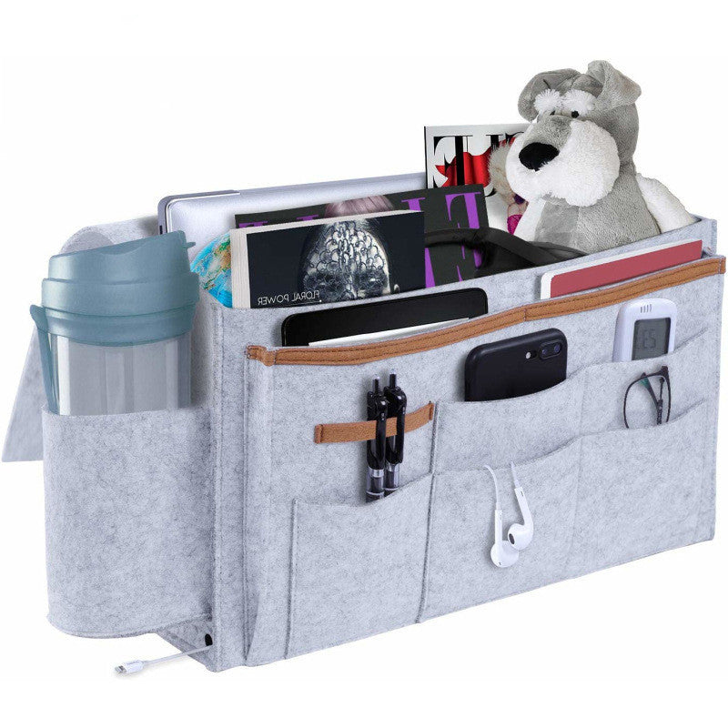 Grey felt bedside storage bag with multiple pockets for organizing essentials like magazines, gadgets, and toys. Available at Shopway.